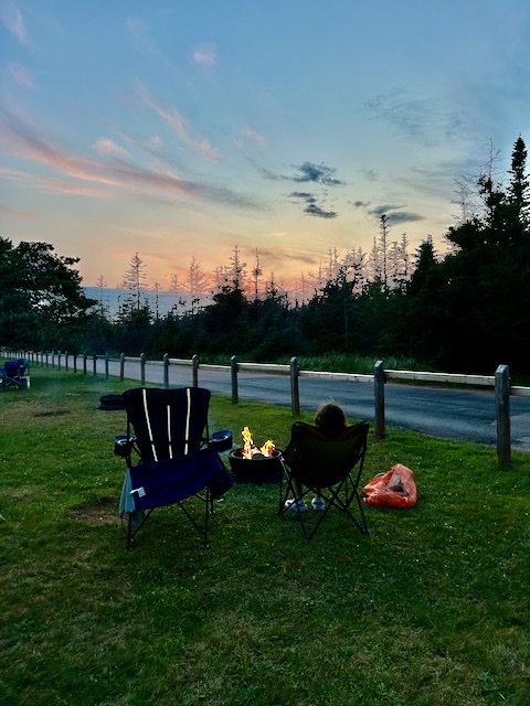 Camp chairs around an evening fire at an Atlantic Canada campsite