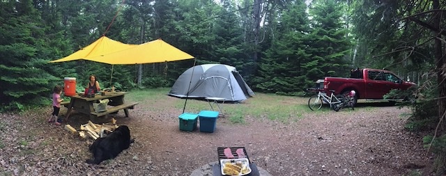 Tarp and tent setup at a forested Atlantic Canada campsite